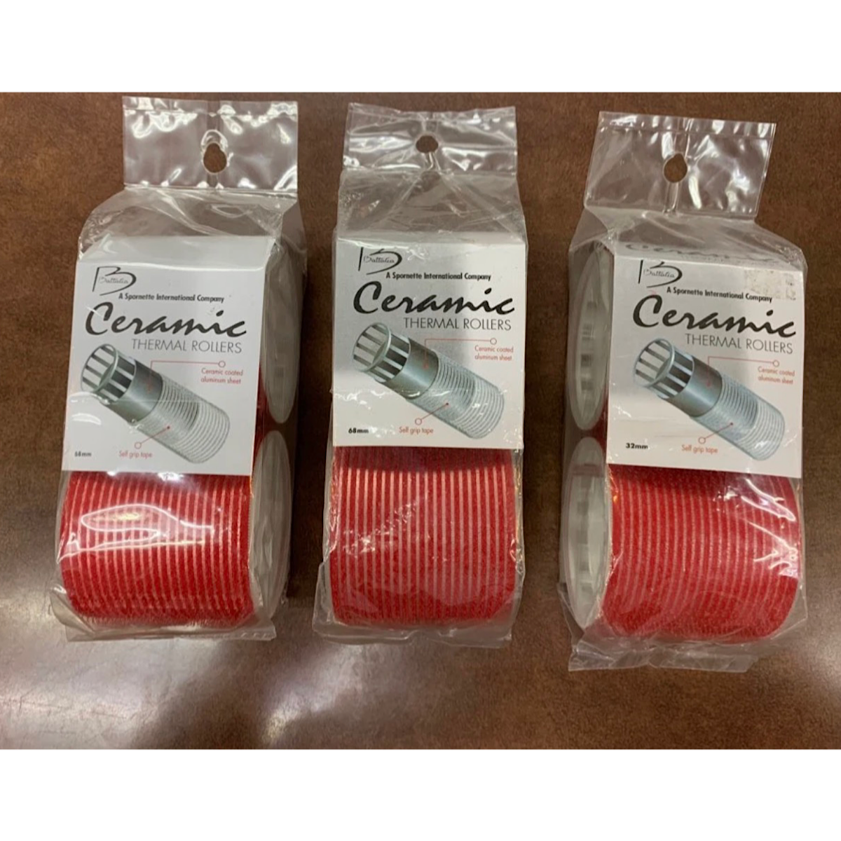 Three packaged rolls of ceramic thermal cooling pastes shown side-by-side on a brown surface. 