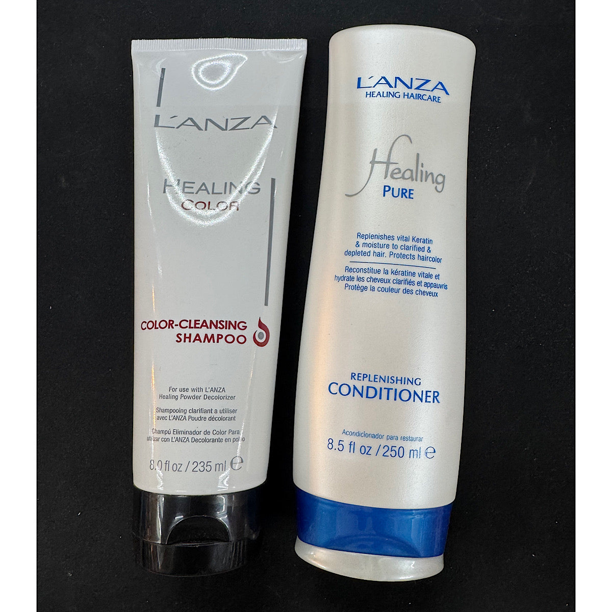 L'ANZA Healing Color Cleansing Shampoo and Healing Pure Replenishing Conditioner set, displayed side-by-side on a black background.
