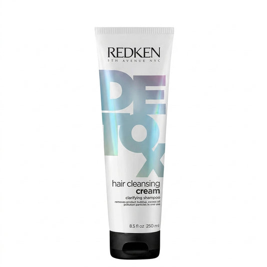 Redken Detox Hair Cleansing Cream clarifying shampoo in a white squeeze tube with a black cap, featuring a large holographic 'DETOX' graphic on a white background.